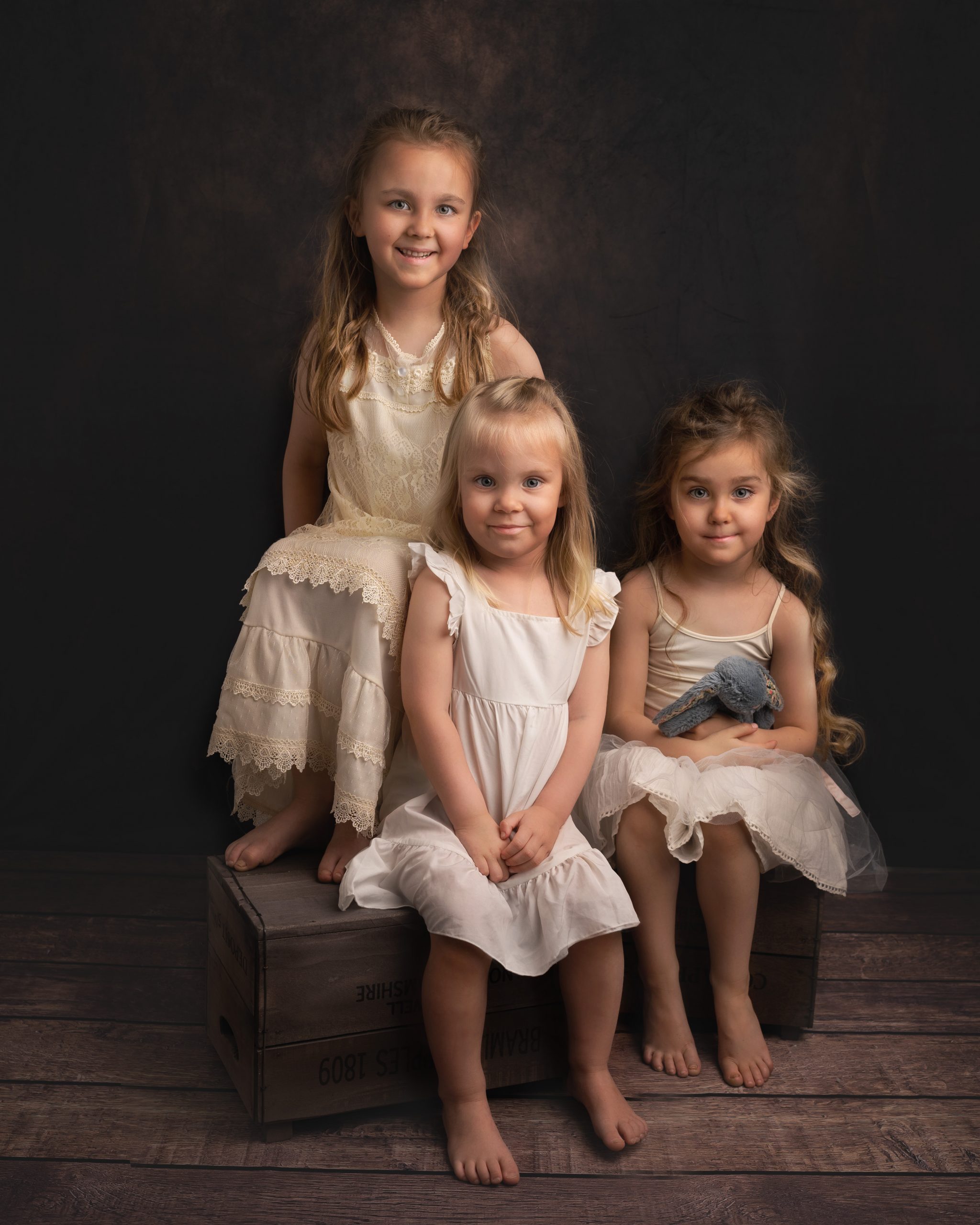 3 little girls sitting together by Family photographer Suffolk