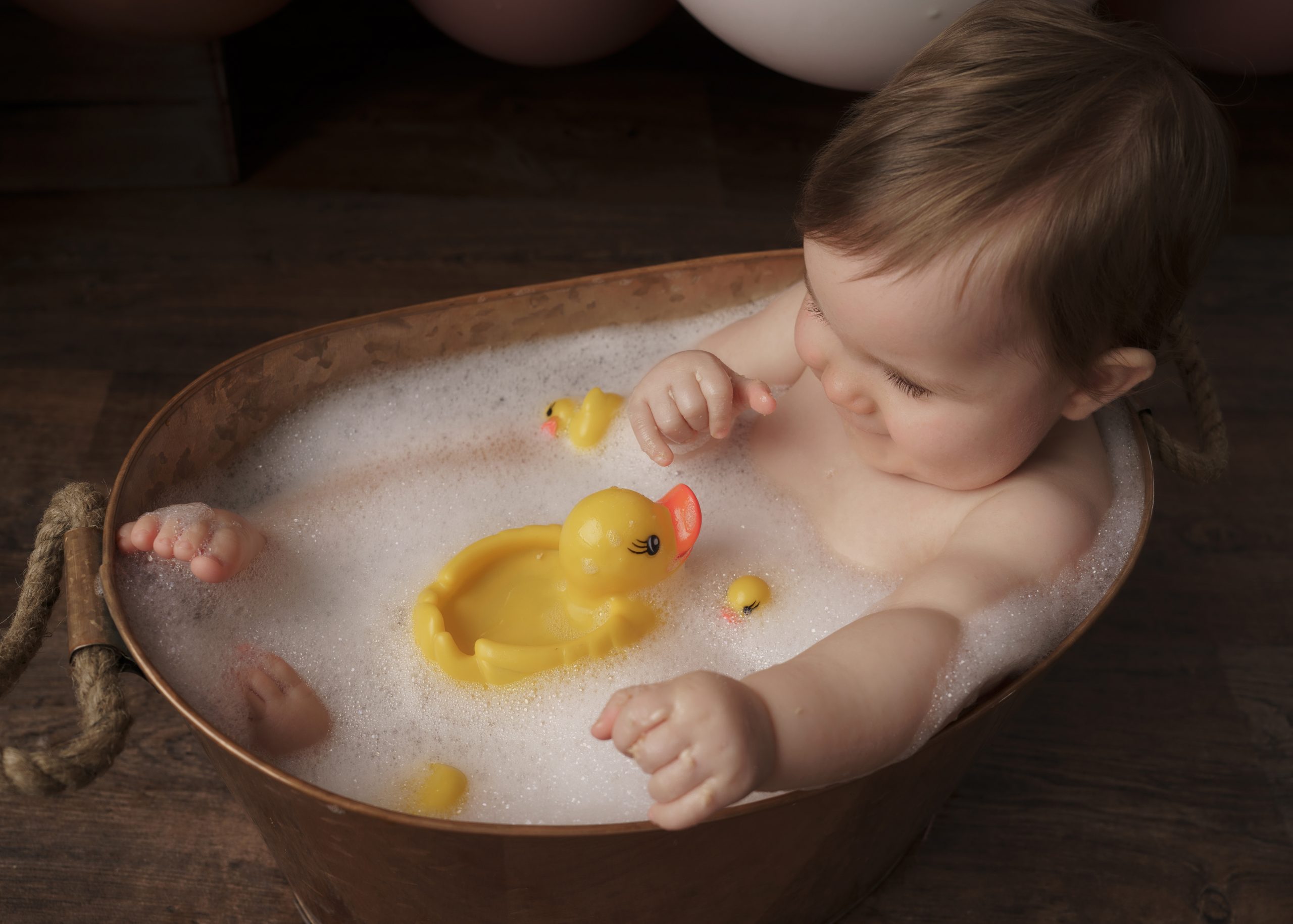 baby girl with rubber duck for cake smash session by baby photographer stowmarket