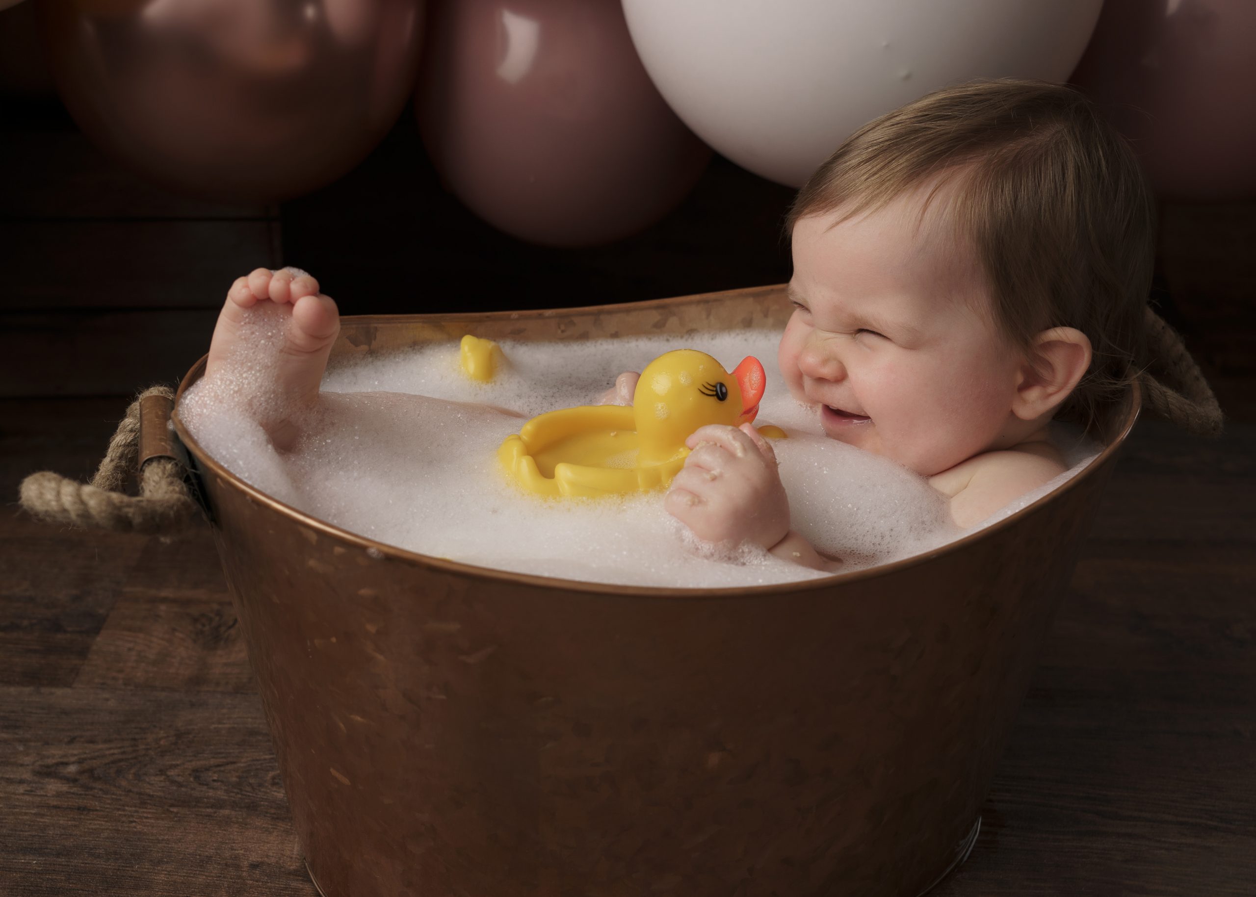 baby girl with rubber duck for cake smash session by baby photographer stowmarket