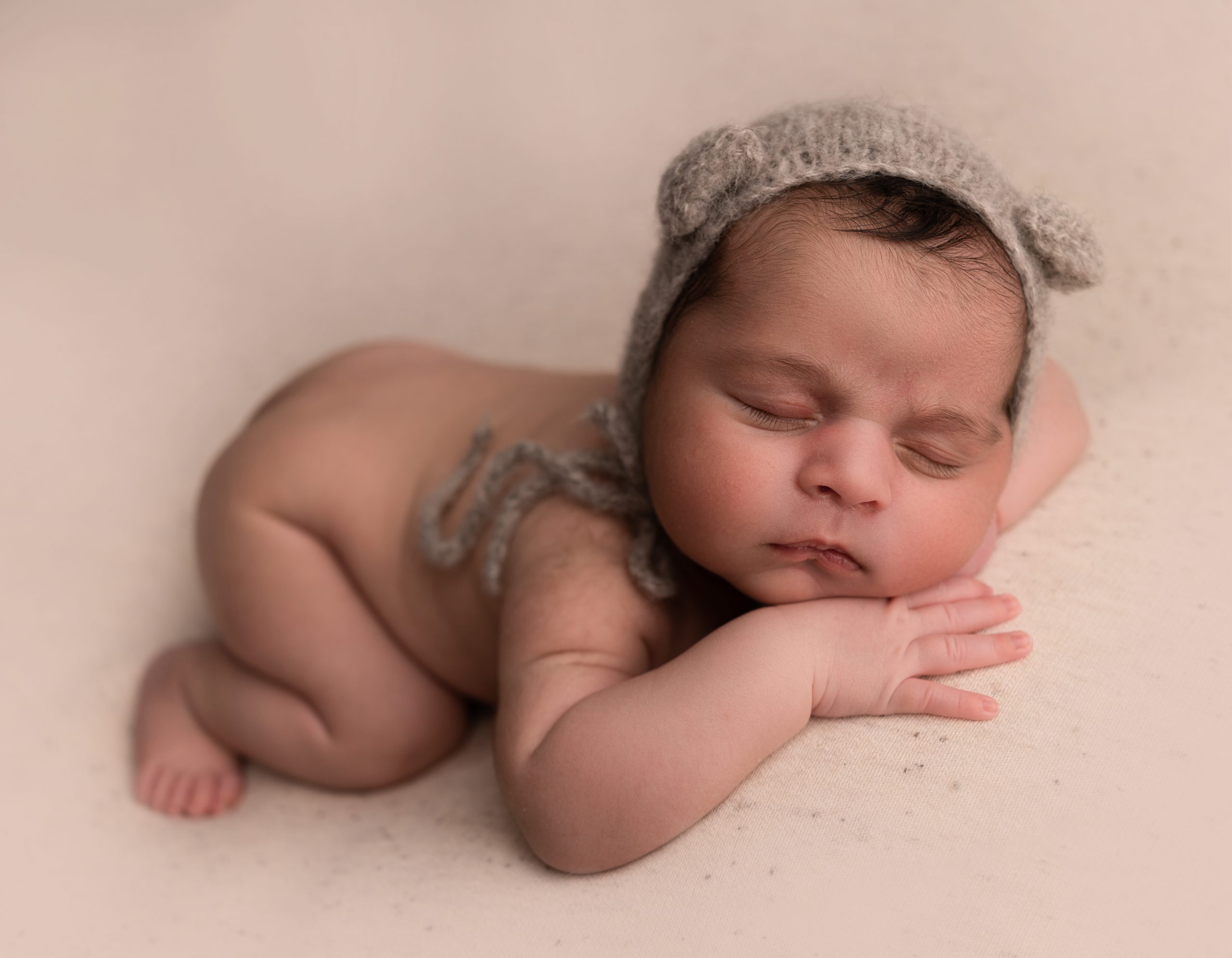 baby boy in teddy bear bonnet by the cow shed studio suffolk